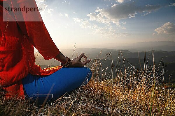 Nahaufnahme  Hand einer Frau im Lotussitz im Gras in den Bergen  Meditation und Entspannung