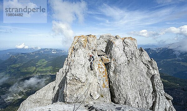 Bergsteigerin klettert in einem mit Stahlseil gesicherten Klettersteig  schmaler felsiger Berggrat  Watzmann Überschreitung zur Watzmann Mittelspitze  Nationalpark Berchtesgaden  Berchtesgadener Alpen  Bayern  Deutschland  Europa