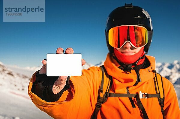 Snowboarder oder Skifahrer mit Blanko Skipass in der Hand  Porträt mit Berg im Hintergrund. Skipass in der Hand Nahaufnahme