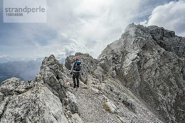 Bergsteigerin auf einem schmalen felsigen Berggrat  Watzmann Überschreitung zur Watzmann Mittelspitze  Nationalpark Berchtesgaden  Berchtesgadener Alpen  Bayern  Deutschland  Europa