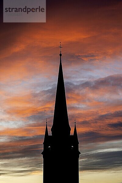 Silhouette vom spätgotischen Kirchturm vom Radolfzeller Münster vor einem dramatischen orangefarbenen und roten Himmel beim Sonnenaufgang  Radolfzell am Bodensee  Landkreis Konstanz  Baden-Württemberg  Deutschland  Europa