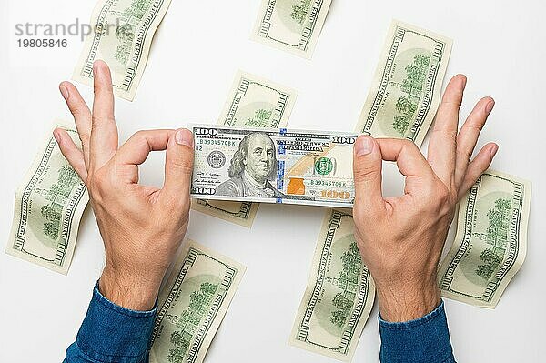 Männerhände halten ein Bündel gefaltetes Geld  Dollarscheine  eine Schuld zurückzahlen. Studioaufnahme  weißer Hintergrund