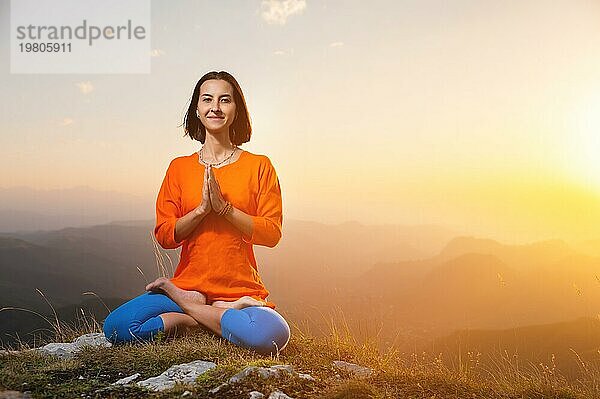 Frau bei Yoga und Meditation in den Bergen bei Sonnenuntergang  Ruhe am Ende des Tages
