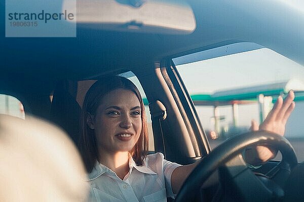 Junge schöne Mädchen Taxifahrer lächelnd hinter dem Lenkrad  freundliche Kommunikation mit den Passagieren