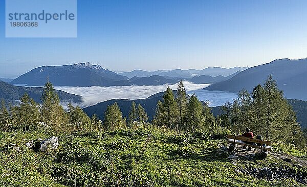 Bergsteiger rastet auf einer Bank  Ausblick auf Bergpanorama und Wolkenmeer  Hochnebel im Tal  Aufstieg zum Watzmann  Nationalpark Berchtesgaden  Berchtesgadener Alpen  Bayern  Deutschland  Europa