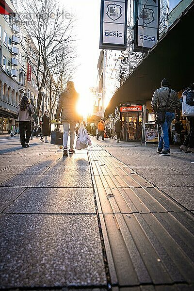 Stadtleben mit Menschen  die bei Sonnenuntergang auf einer belebten Straße einkaufen  Stuttgart  Deutschland  Europa