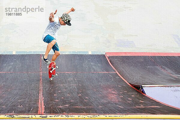 Junge macht einen Trick mit einem Sprung auf der Rampe im Skatepark. Foto mit Platz für Copyspace