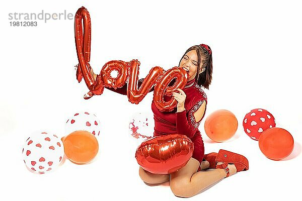 Schönes junges Mädchen hält ein Zeichen mit Wort: Liebe. Spielerische  ironische Haltung gegenüber Valentinstag Konzept. Konzept der Selbstliebe