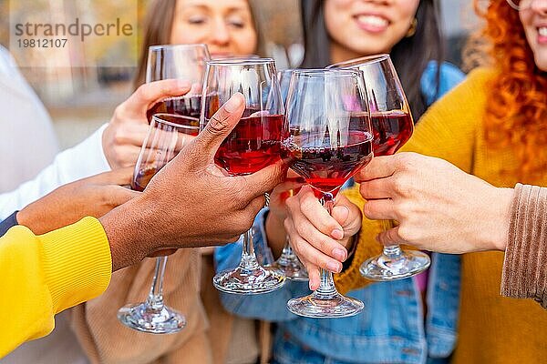 Nahaufnahme von Freunden  die auf einer Straße in der Stadt feiern und mit Wein anstoßen