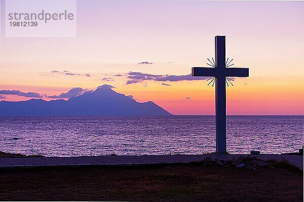 Silhouette von Kreuz und Berg Athos bei Sonnenaufgang oder Sonnenuntergang und Meerespanorama in Griechenland