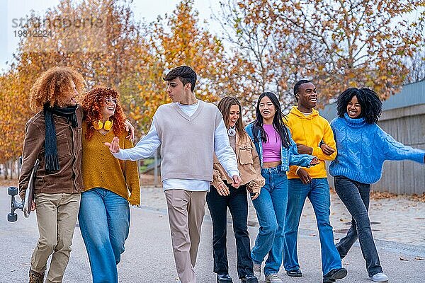 Multiethnische Studenten  die über den Campus spazieren  sich unterhalten und umarmen