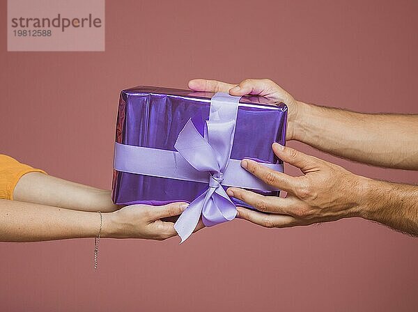 Close up Hände halten lila verpackt Geschenkbox