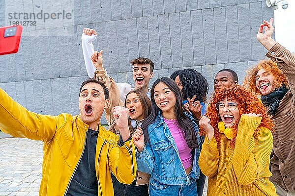 Aufgeregte Gruppe multiethnischer Freunde  die bei der Aufnahme eines Selfies im Freien feiern