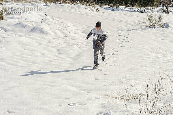 Junger Mann hat Spaß beim Laufen im großen Schnee