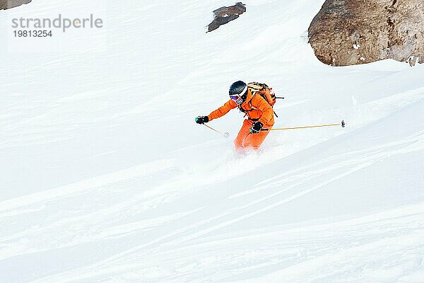 Ein Skisportler saust im frischen Pulverschnee die Piste hinunter. Das Konzept des Winterskisports