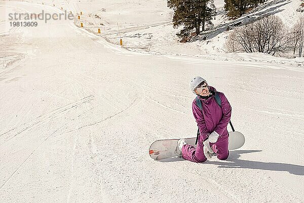 Schöne Anfängerin Snowboarderin in den kaukasischen Bergen