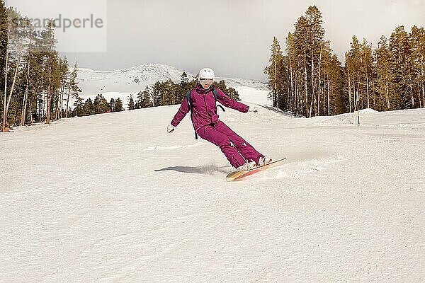 Schöne Anfängerin Snowboarderin in den kaukasischen Bergen