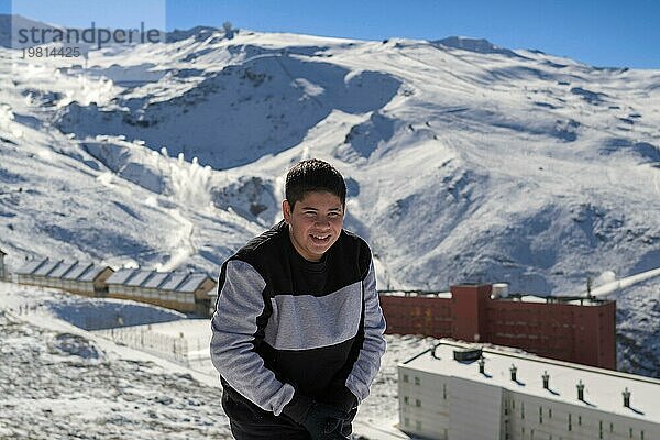 Junger lateinamerikanischer Mann mit Erkältung  der im Schnee spielt  Skigebiet sierra nevada  granada  spanien