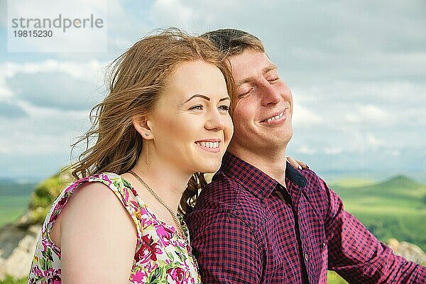 Junges Ehepaar glücklich lachend in der Natur vor dem Hintergrund von Felsen und Steinen. Konzept einer glücklichen jungen Familie