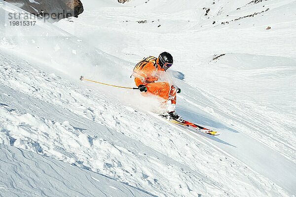 Ein Skisportler saust im frischen Pulverschnee die Piste hinunter. Das Konzept des Winterskisports