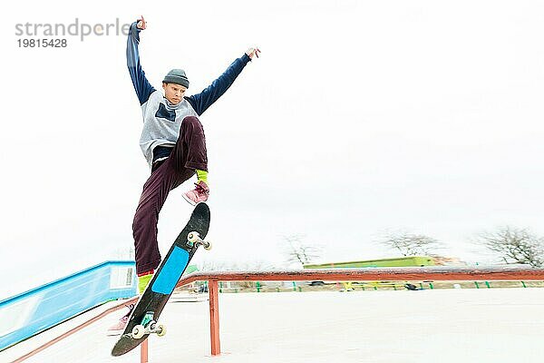 Ein junger Teenager  ein Skateboarder  macht einen Trick auf dem Geländer in einem Skatepark. Das Konzept des Jugendsports in der städtischen Kultur