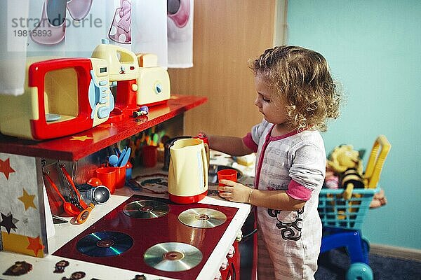 Mädchen spielt mit Spielzeugküche