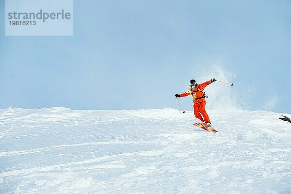 Ein Skisportler saust im frischen Pulverschnee die Piste hinunter. Das Konzept des Winterskisports