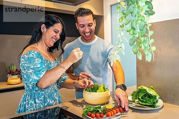 Ein frisch verheiratetes Paar bereitet zu Hause in einer neuen Küche gesundes Essen zu