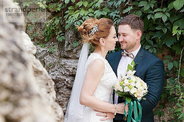 Close up Porträt eines schönen liebenden Paar von Jungvermählten vor dem Hintergrund der Sommergrüns. Das Konzept des glücklichen Lebens der Hipster in der Ehe