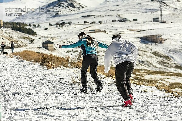 Eisige Abenteuer erwarten Sie! Eine Latino Familie vergnügt sich in den verschneiten Hügeln der Sierra Nevada  Granada  mit frostigem Spaß