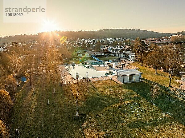 Sonnenuntergangsstimmung im Freibad mit Reflexionen im Wasser und Silhouetten der Dorflandschaft  Freibad Calw  Stammheim der Stadtwerke Calw  Schwarzwald  Deutschland  Europa