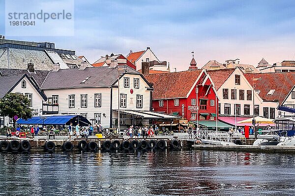 Stavanger  Norwegen  2. August 2018: Stadtansicht mit Menschen  Cafés  Restaurants und bunten traditionellen Holzhäusern an der Promenade in Hafennähe  Europa