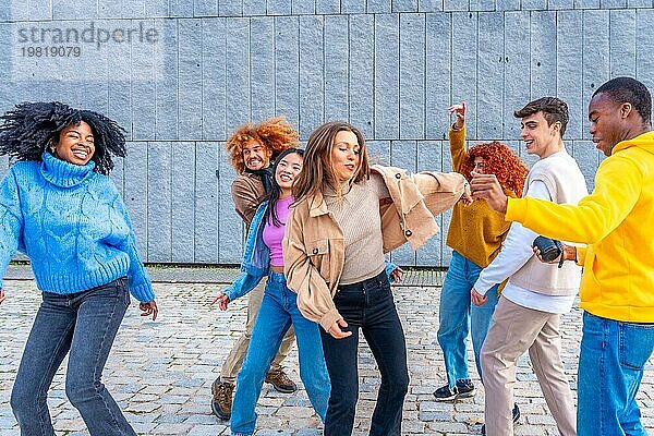 Multiethnische junge Freunde tanzen zusammen auf der Straße