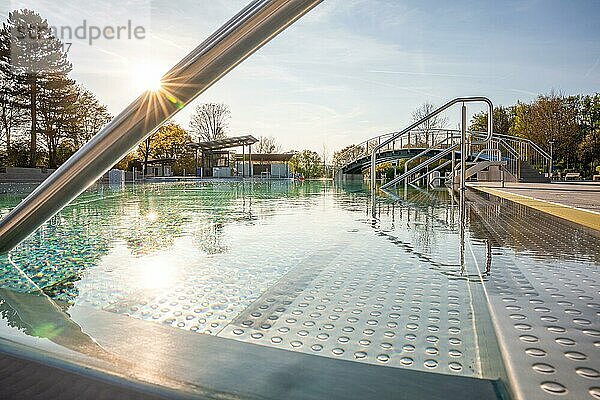 Schwarm von Sonnenstrahlen über einem ruhigen Schwimmbad hinter Edelstahlgeländern  Freibad Calw  Stammheim der Stadtwerke Calw  Schwarzwald  Deutschland  Europa