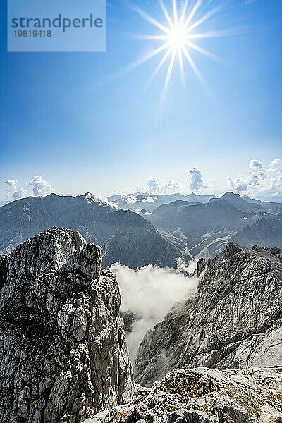 Ausblick vom Gipfel des Hochkalter  felsige steile Berglandschaft  hinten Gipfel des Watzmann Grat  Sonnenstern  Berchtesgadener Alpen  Bayern  Deutschland  Europa