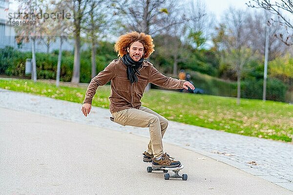 Foto mit Bewegung und Kopierraum eines glücklichen jungen Mannes beim Skateboardfahren in einem Stadtpark