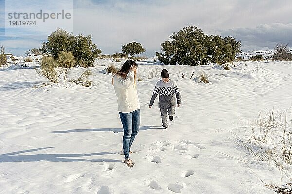 Kind und Mutter haben Spaß in verschneiter Landschaft