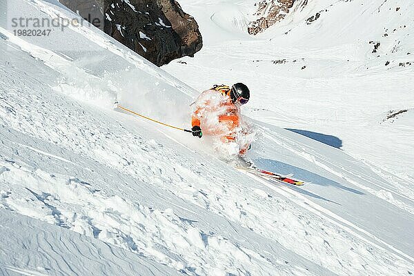 Ein Skisportler saust im frischen Pulverschnee die Piste hinunter. Das Konzept des Winterskisports