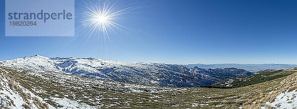 Panoramablick auf schneebedeckte Berge bei strahlend blauem Himmel und Sonnenschein