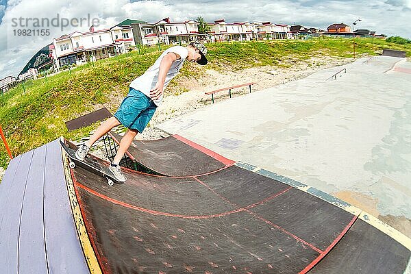 Junge macht einen Trick auf einer Rampe in einem Skatepark. Foto mit Platz für Copyspace