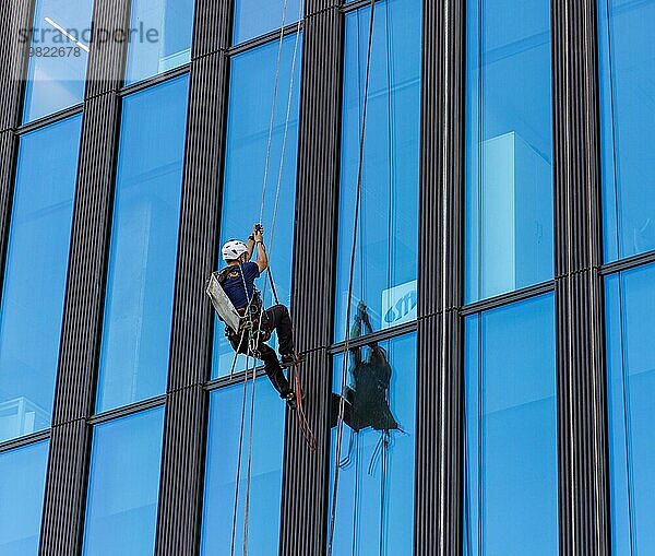 Ein Bild eines Fensterputzers  der auf ein Bürogebäude klettert