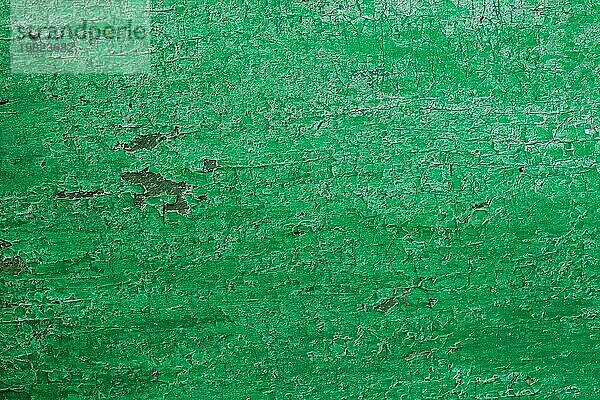 Textur eines Holzbretts in Grün  Rissige grüne Farbe auf einer Holzoberfläche aus der Zeit