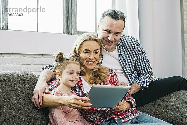 Glückliche Familie mit digitalem Tablet Sofa Wohnzimmer