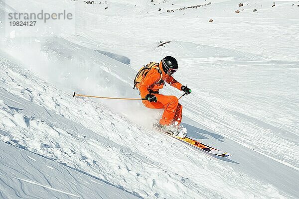 Ein Skisportler saust im frischen Pulverschnee die Piste hinunter. Das Konzept des Winterskisports