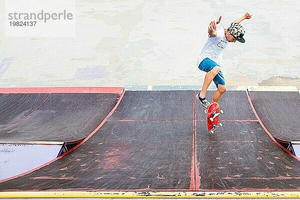 Junge macht einen Trick mit einem Sprung auf der Rampe im Skatepark. Foto mit Platz für Copyspace