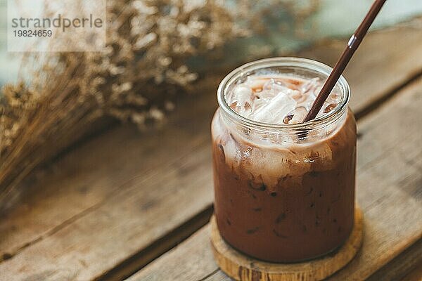 Leckere gefrorene Schokolade Milch Kakao in einem Glas auf Vintage Holz Hintergrund  selektiver Fokus
