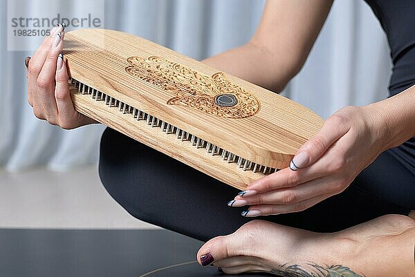 Bild eines Sadhu Boards in weiblichen Händen. Yoga Konzept. Spirituelle Praktiken. Gemischte Medien