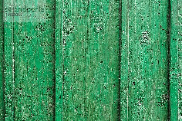 Textur eines Holzbretts in Grün  Rissige grüne Farbe auf einer Holzoberfläche aus der Zeit