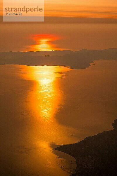 Luftaufnahme von Sonnenuntergang oder Sonnenaufgang  Sonne Berge Silhouette  Schuss aus dem Flugzeug