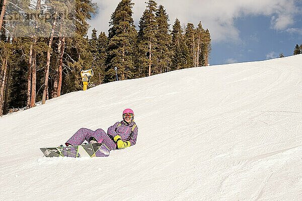 Schöne Anfängerin Snowboarderin in den kaukasischen Bergen